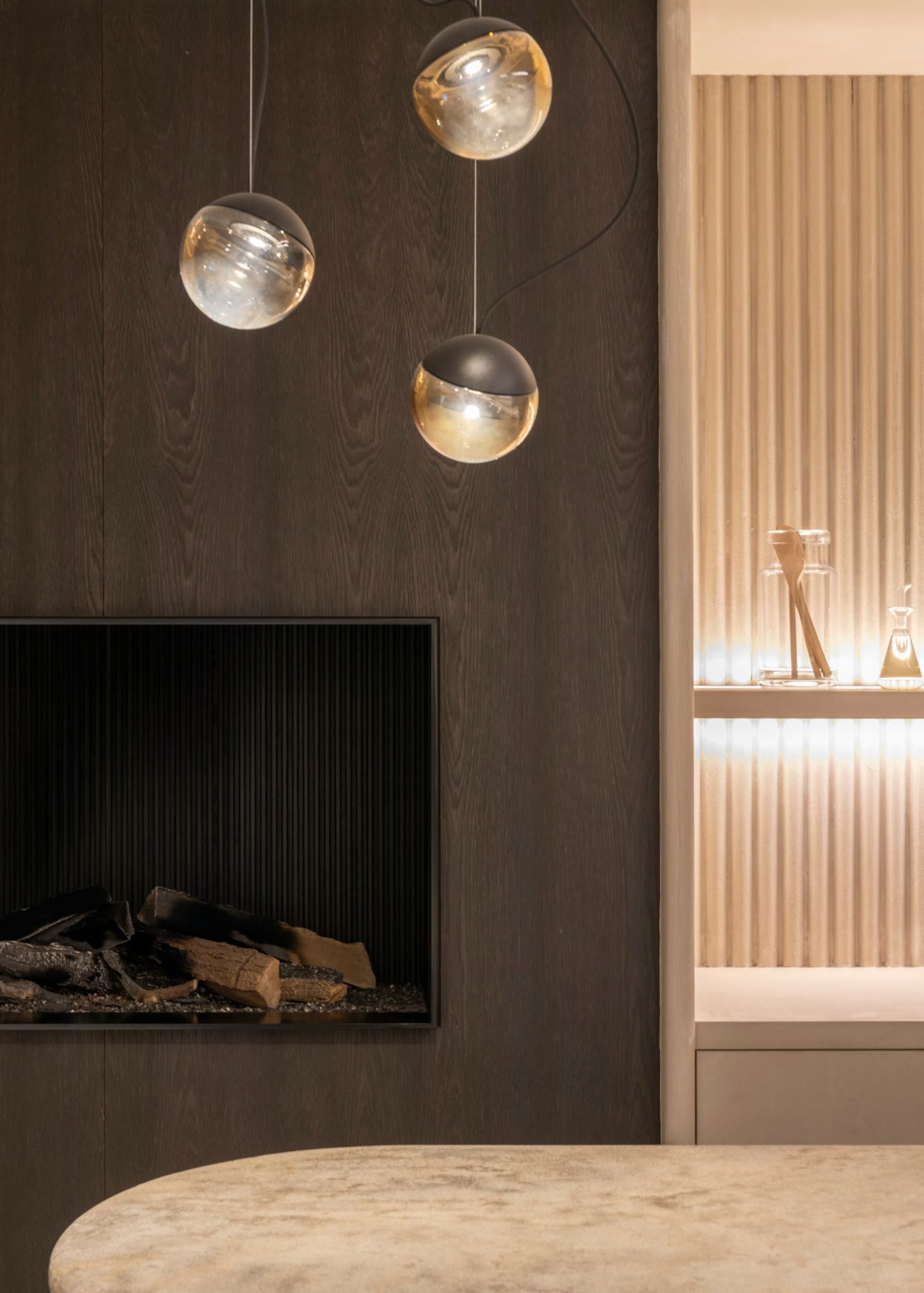 Dark oak fireplace wall with glass pendant lights