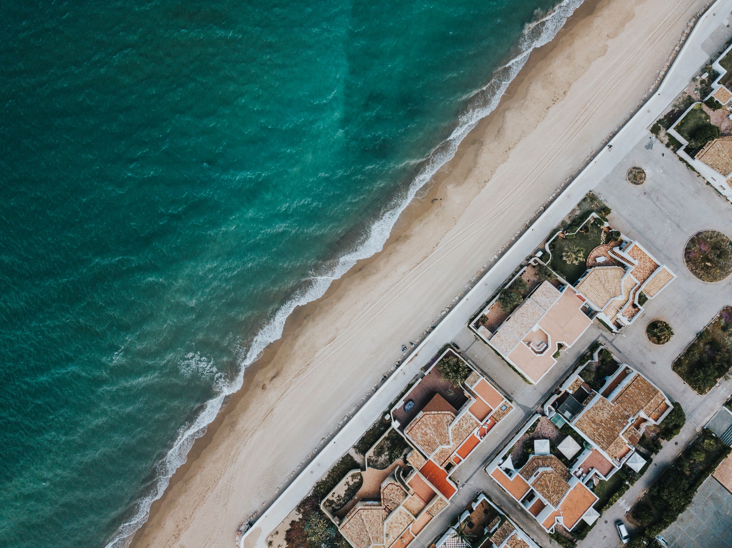 Aerial view of a beach, surf and coastal homes