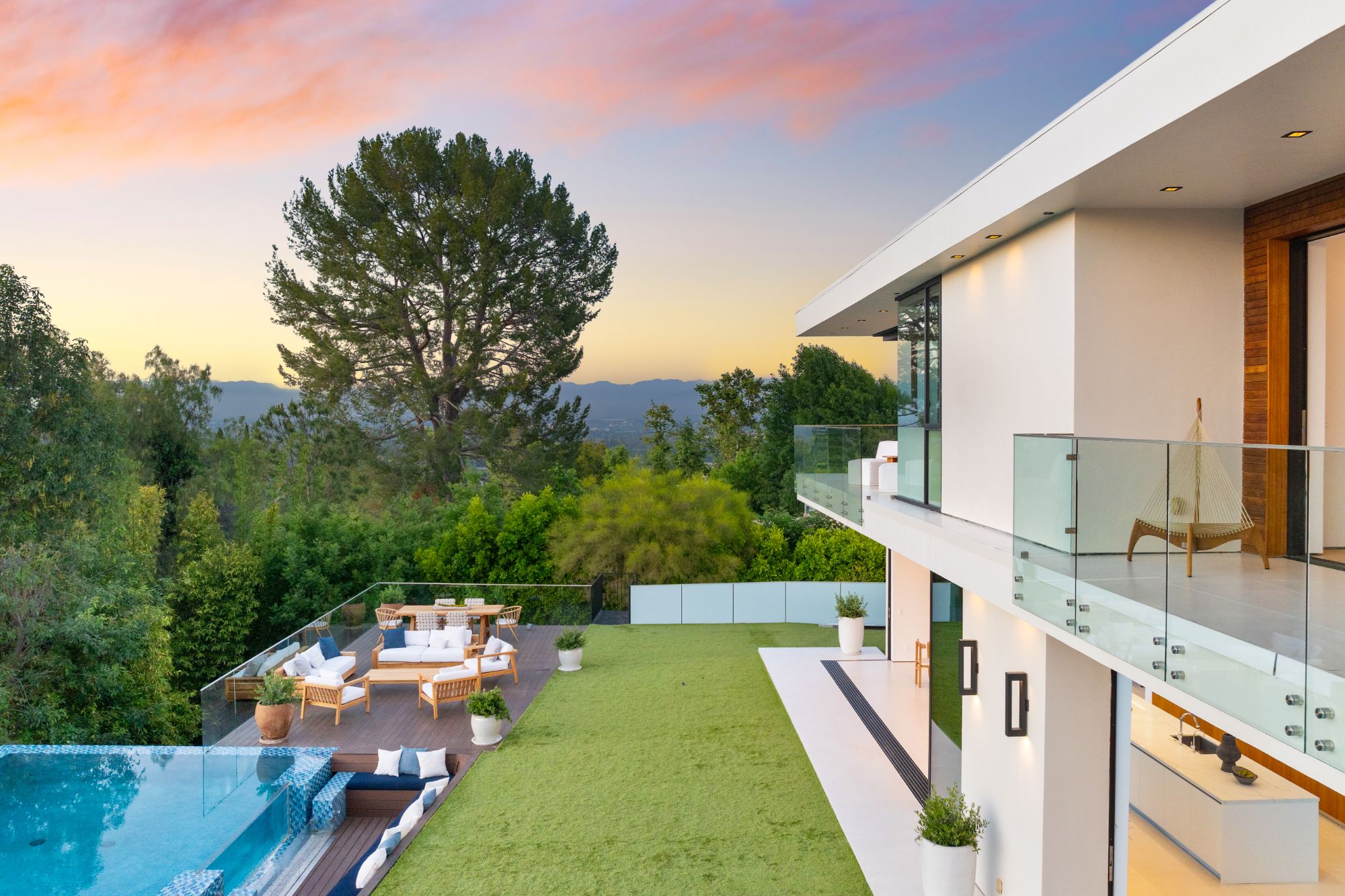 Hillside terrace, garden, and pool at sunset, looking out to the mountains