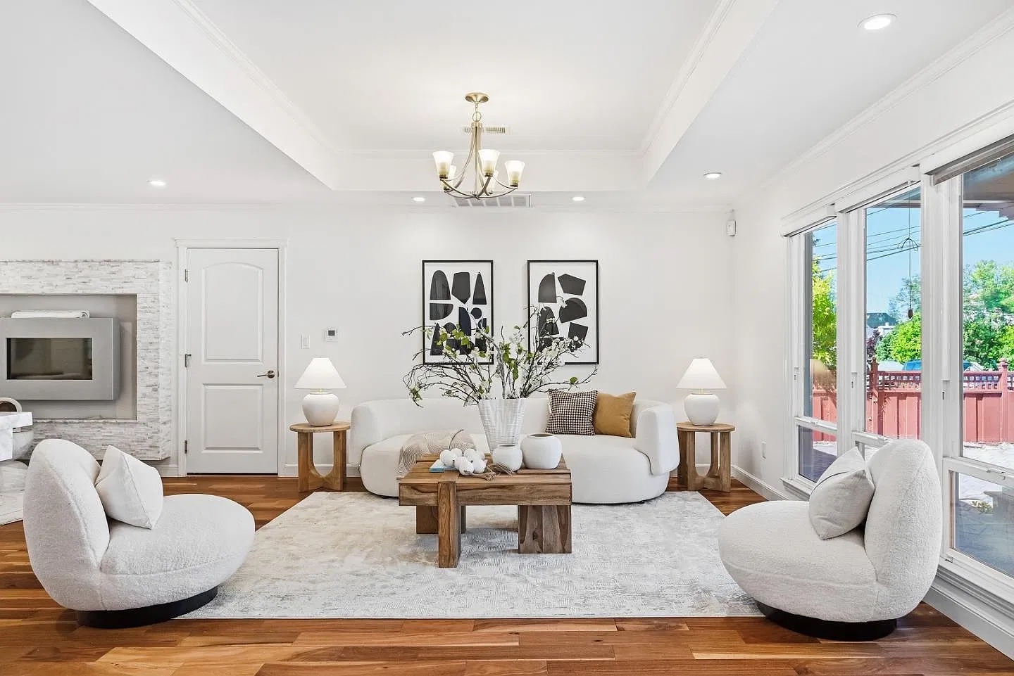 Bright white living room with curved sofas and walnut floors